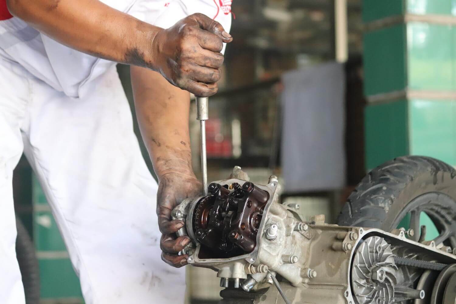 A technician is repairing a motorcycle engine
