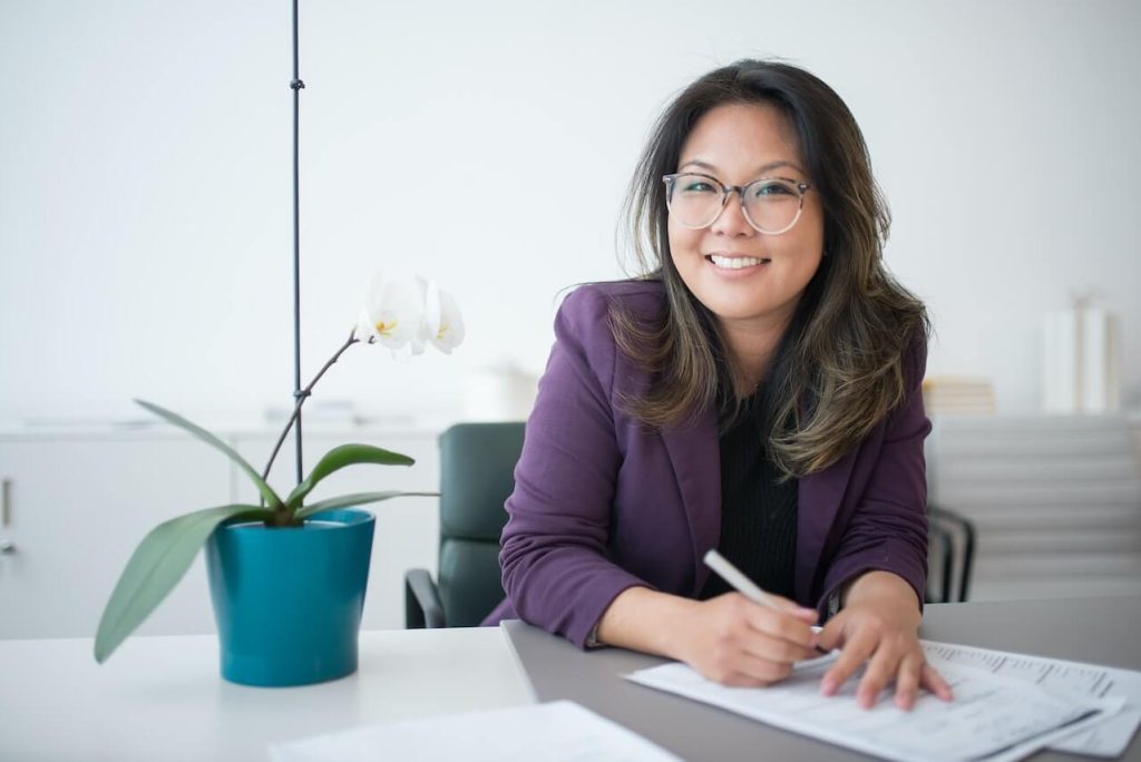 A Woman Sitting on a Table with Potted Plant