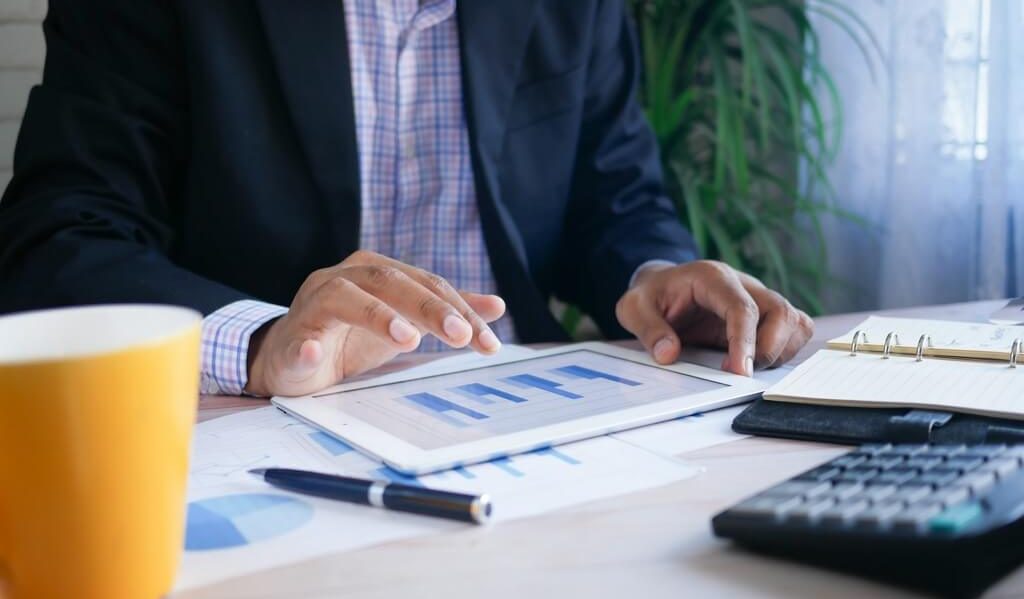 Man sitting at a desk holding a report