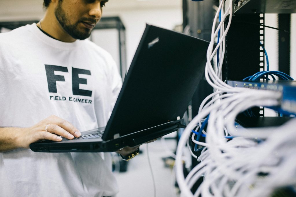 Man holding a laptop and using CMS for preventive maintenance