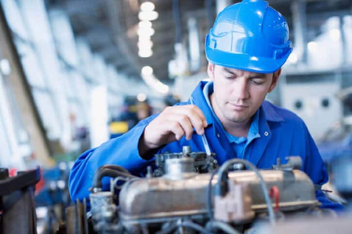 Man with a helmet fixing a machine