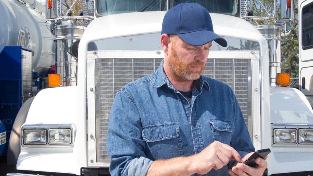 Man in front of a truck holding ELD