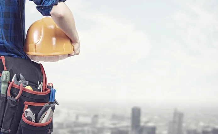 Person holding a helmet and looking at the city from above